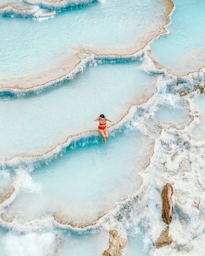 A woman enjoys a peaceful moment in Saturnias stunning thermal baths, Tuscany, Italy.